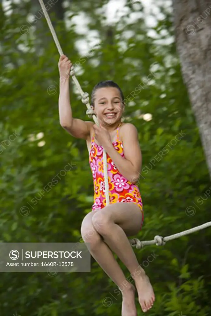 Portrait of a girl swinging on a rope