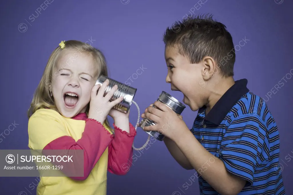 Boy and a girl playing with a tin can phone