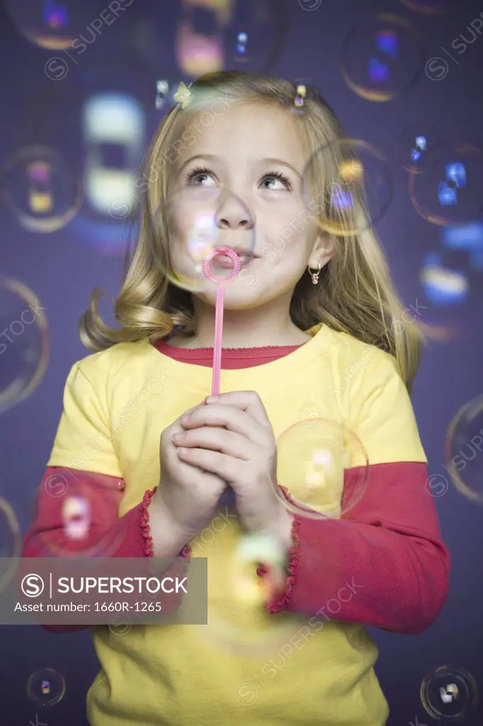 Close-up of a girl blowing bubbles with a bubble wand