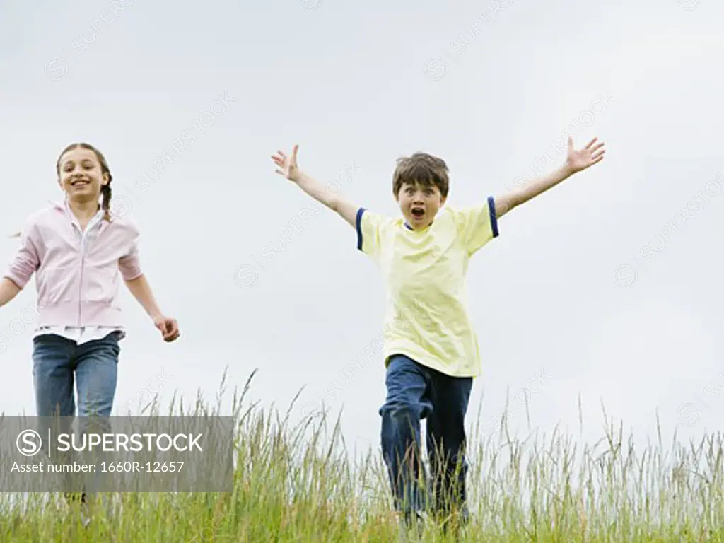 Boy and a girl running in a field