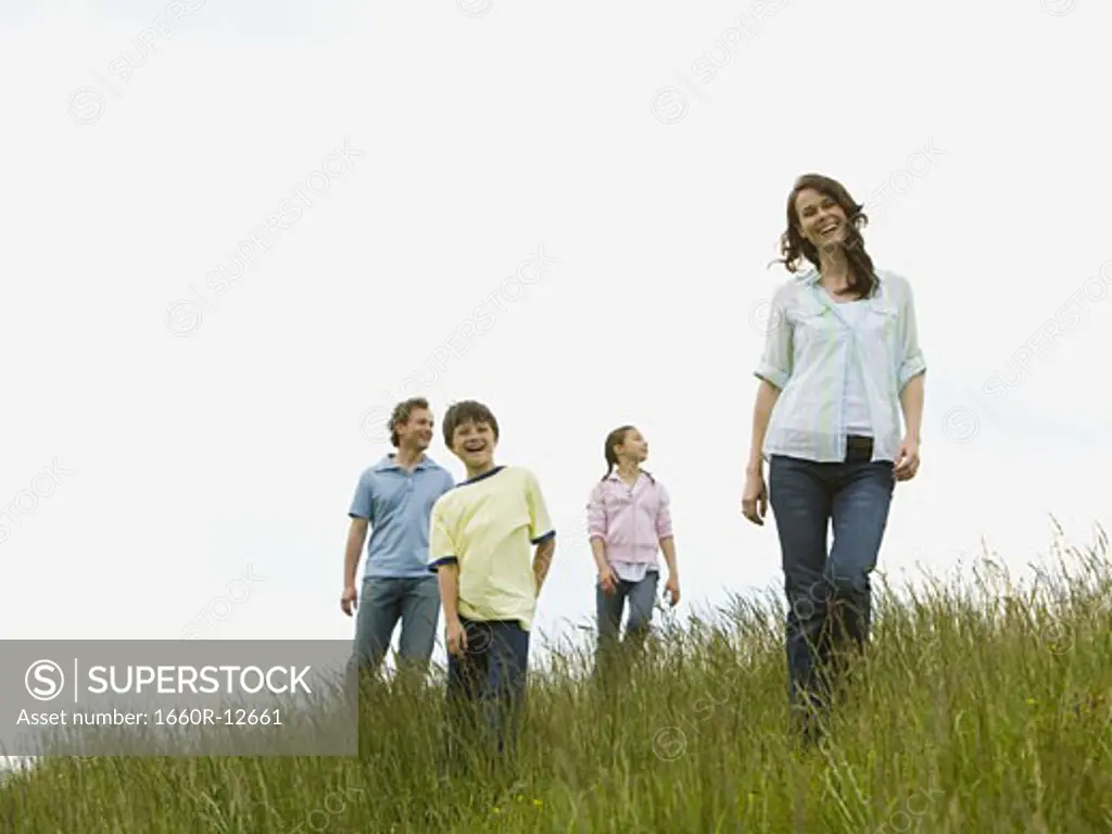 Low angle view of a woman and a man with their son and daughter in a field