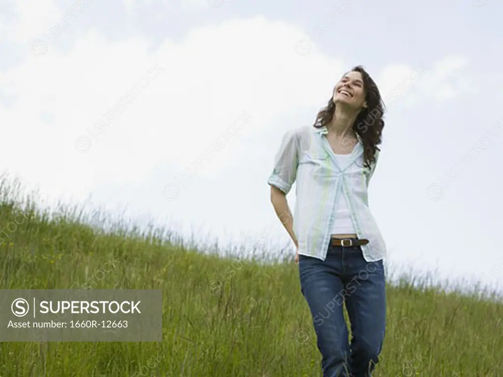 Low angle view of a woman laughing in a field