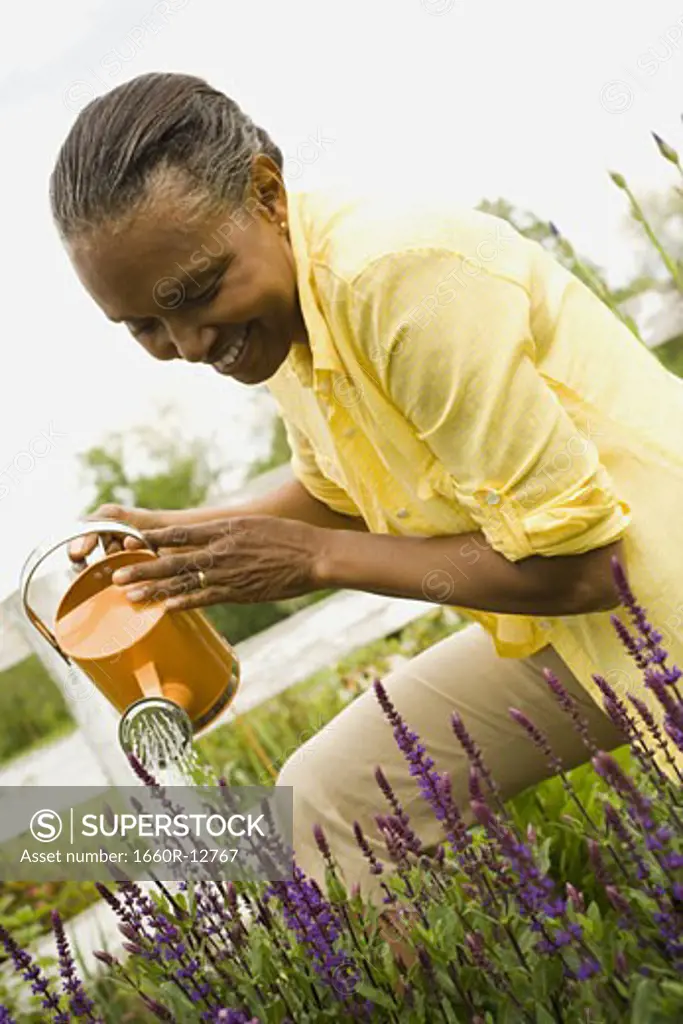 Close-up of a senior woman watering flowers