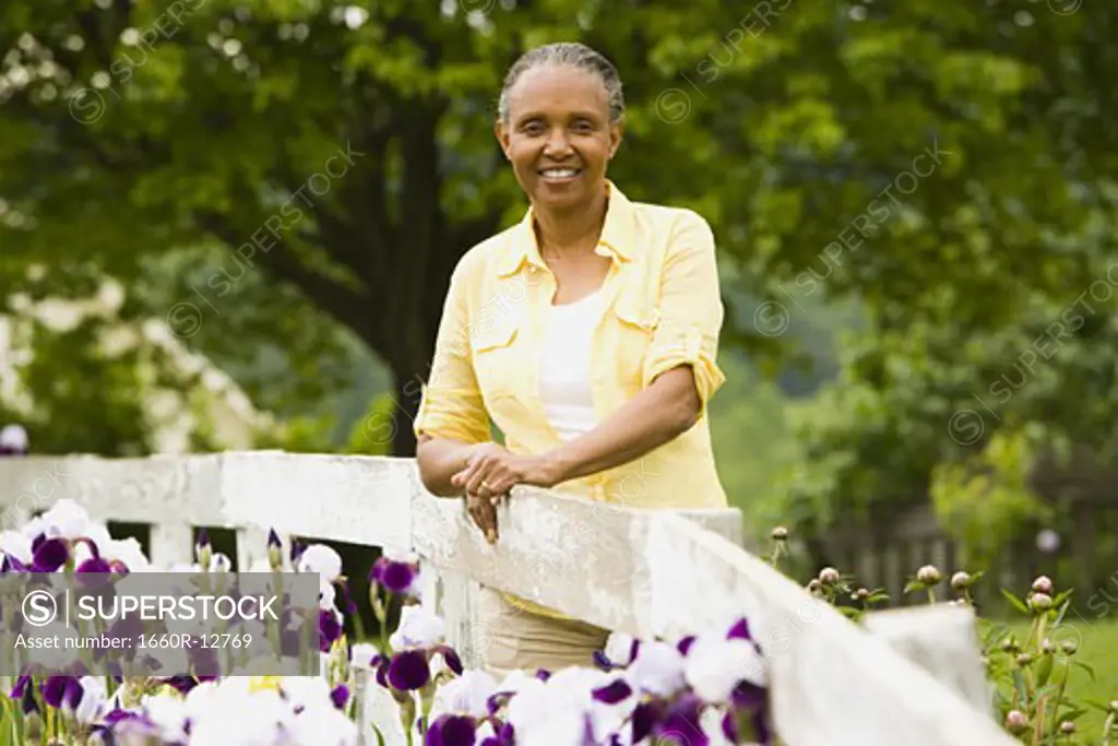 Portrait of a senior woman next to a fence