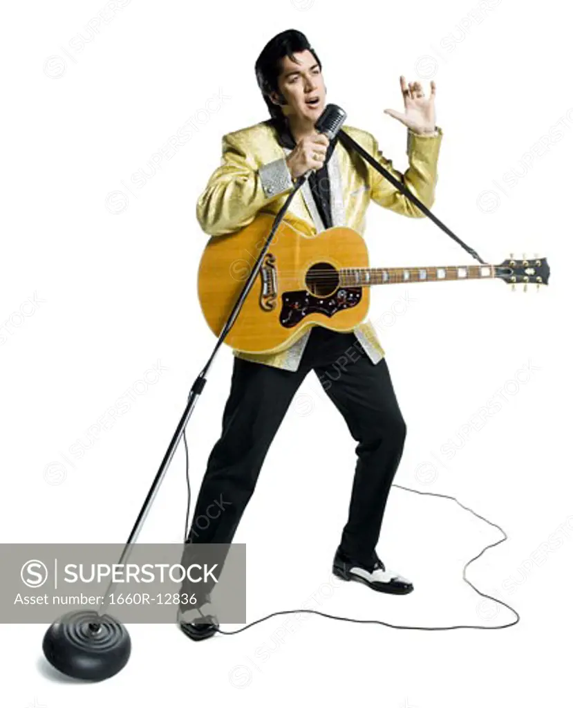 An Elvis impersonator singing into a microphone