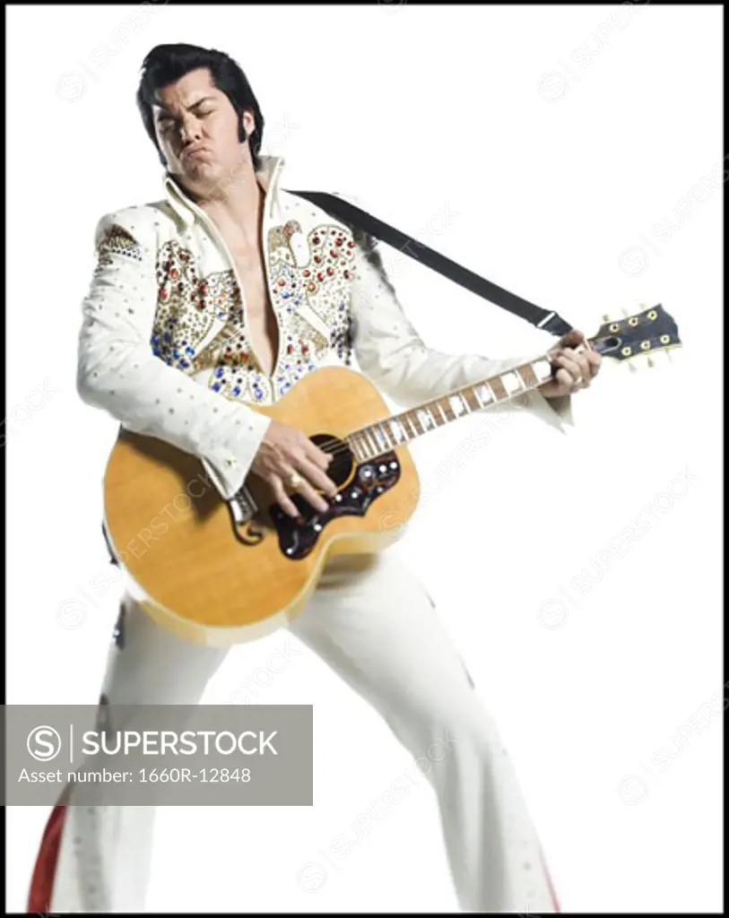 An Elvis impersonator playing the guitar