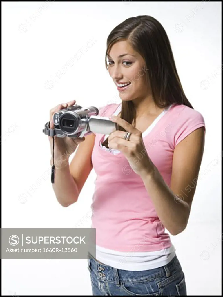 A young woman filming with a home video camera