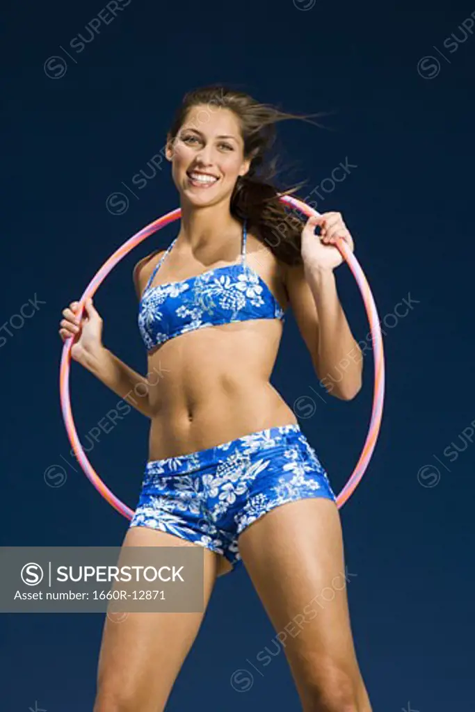 Portrait of a young woman holding a hula hoop and smiling