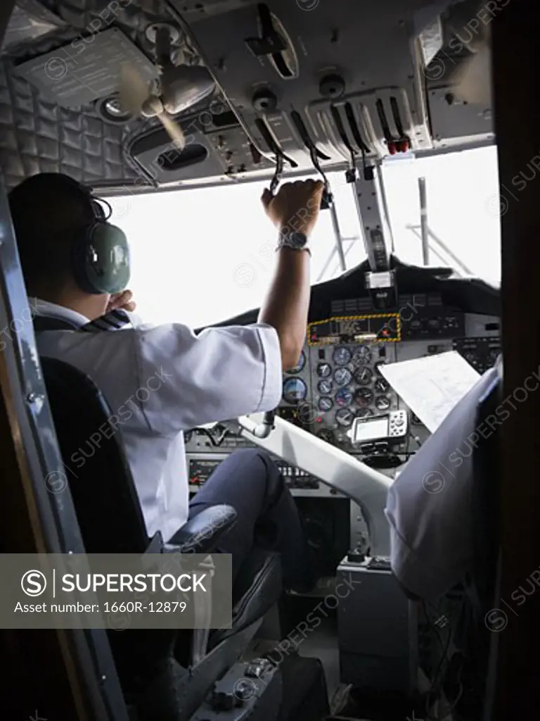 Rear view of two pilots sitting in airplane cockpit