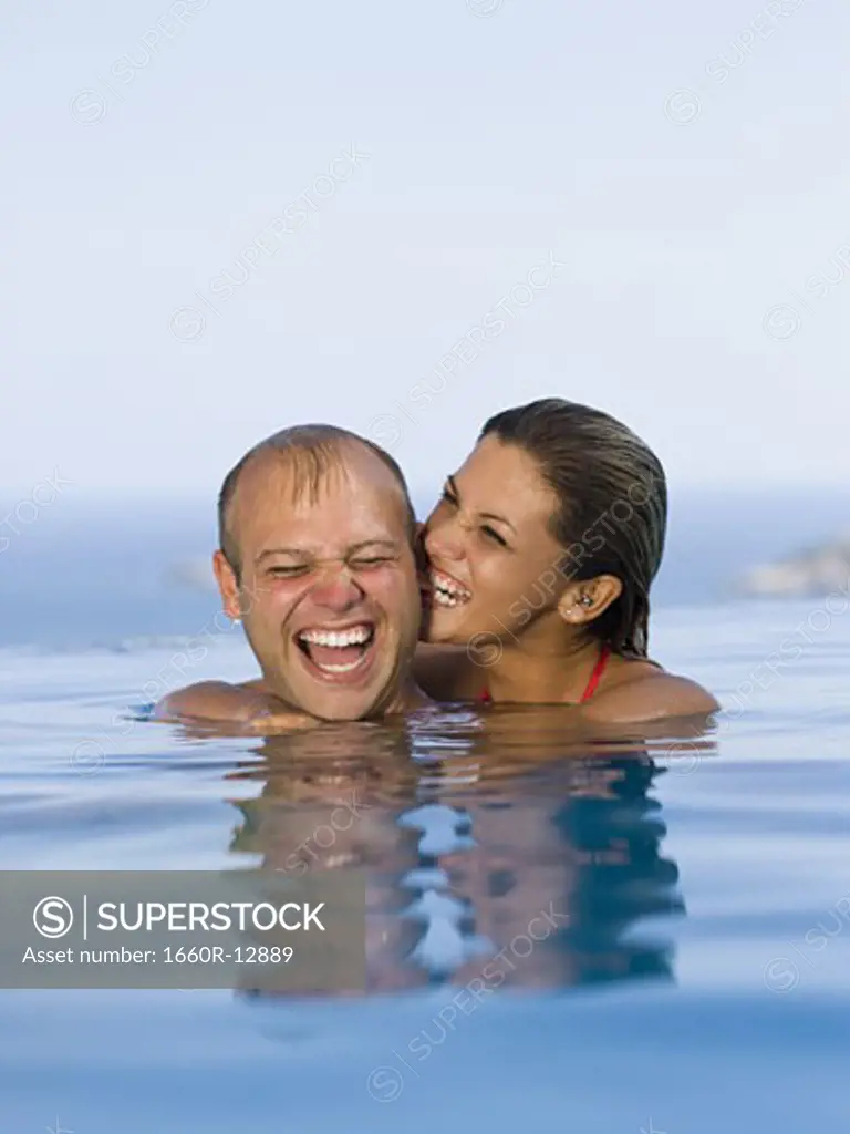 Mid adult couple smiling together in a swimming pool