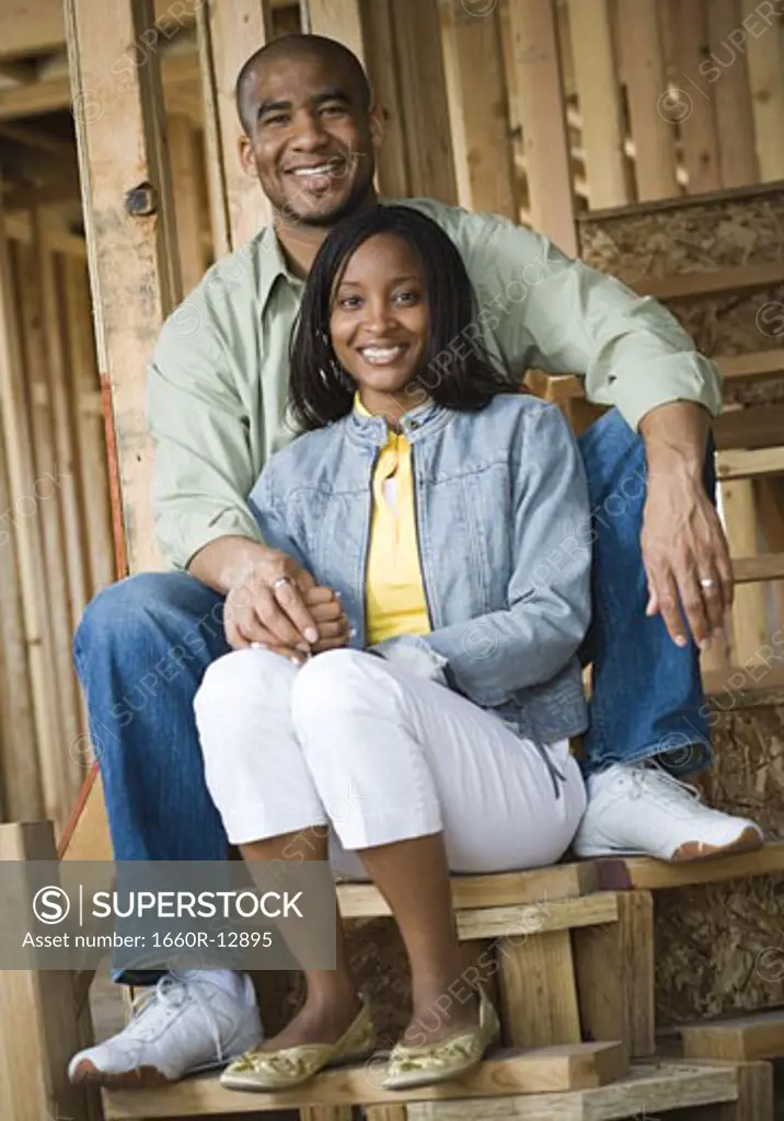 Portrait of a young couple sitting on a staircase and smiling