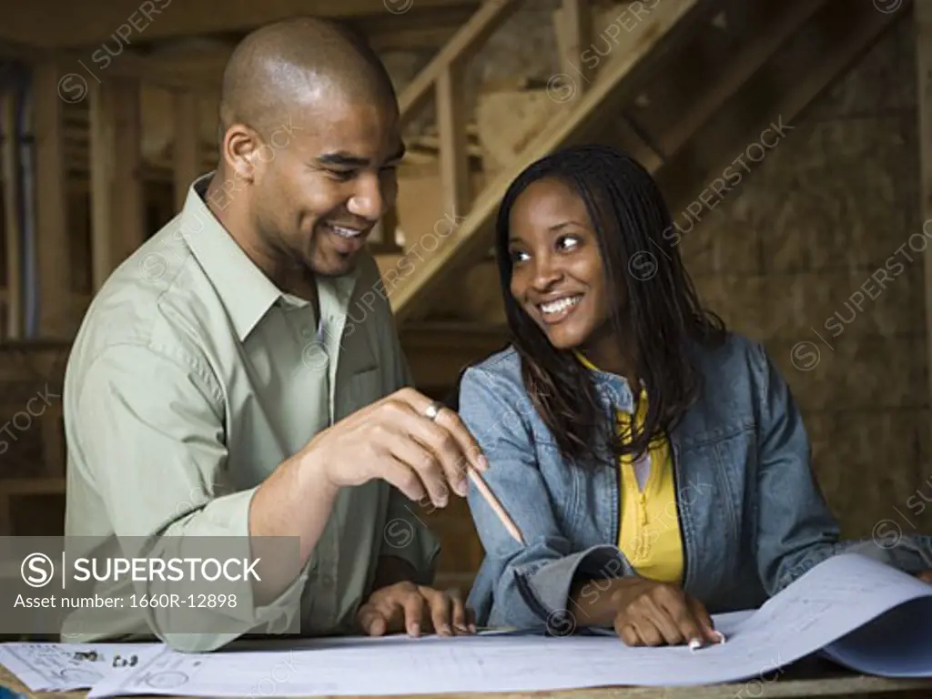 Young couple discussing a blueprint