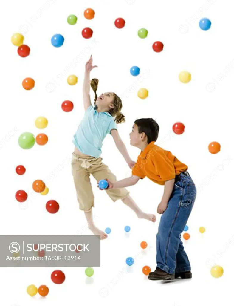 A boy and a girl playing with colorful balls
