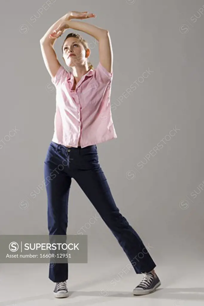 Young woman standing with her arms raised