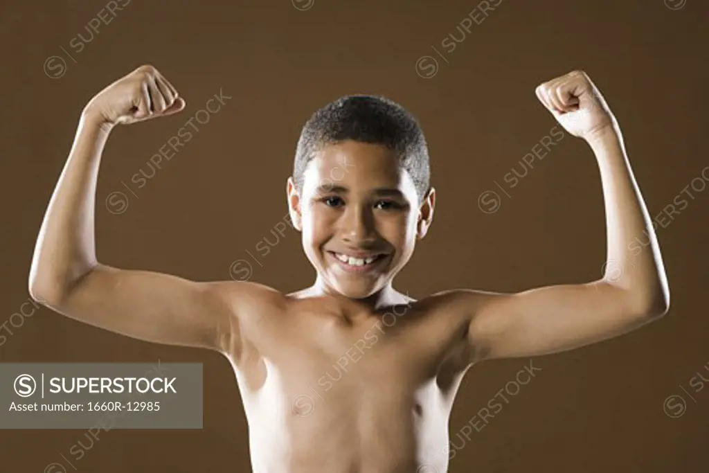 Portrait of a boy flexing his muscles