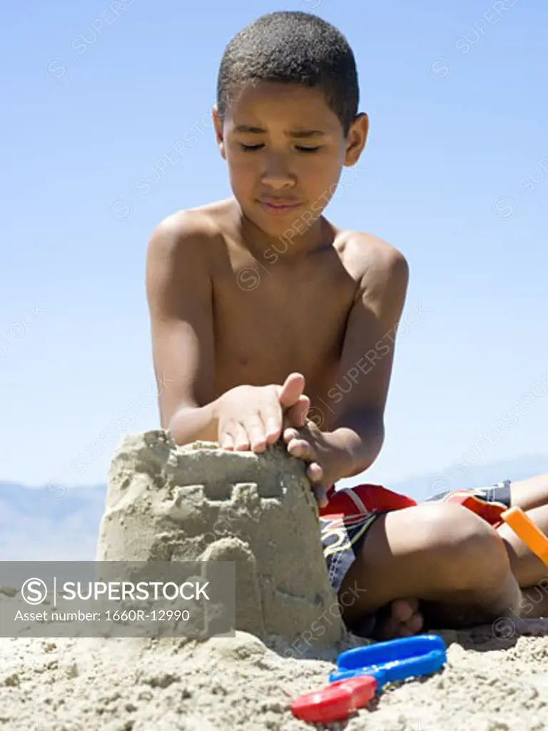 Close-up of a boy making a sand castle