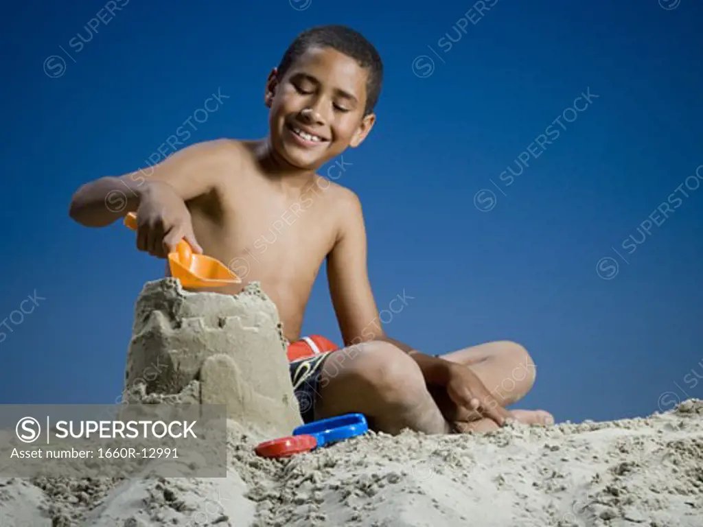 Low angle view of a boy making a sand castle