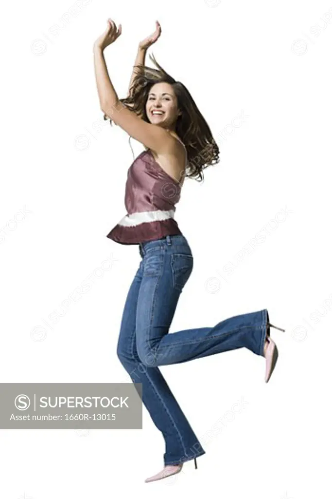 A young woman jumping with her arms raised