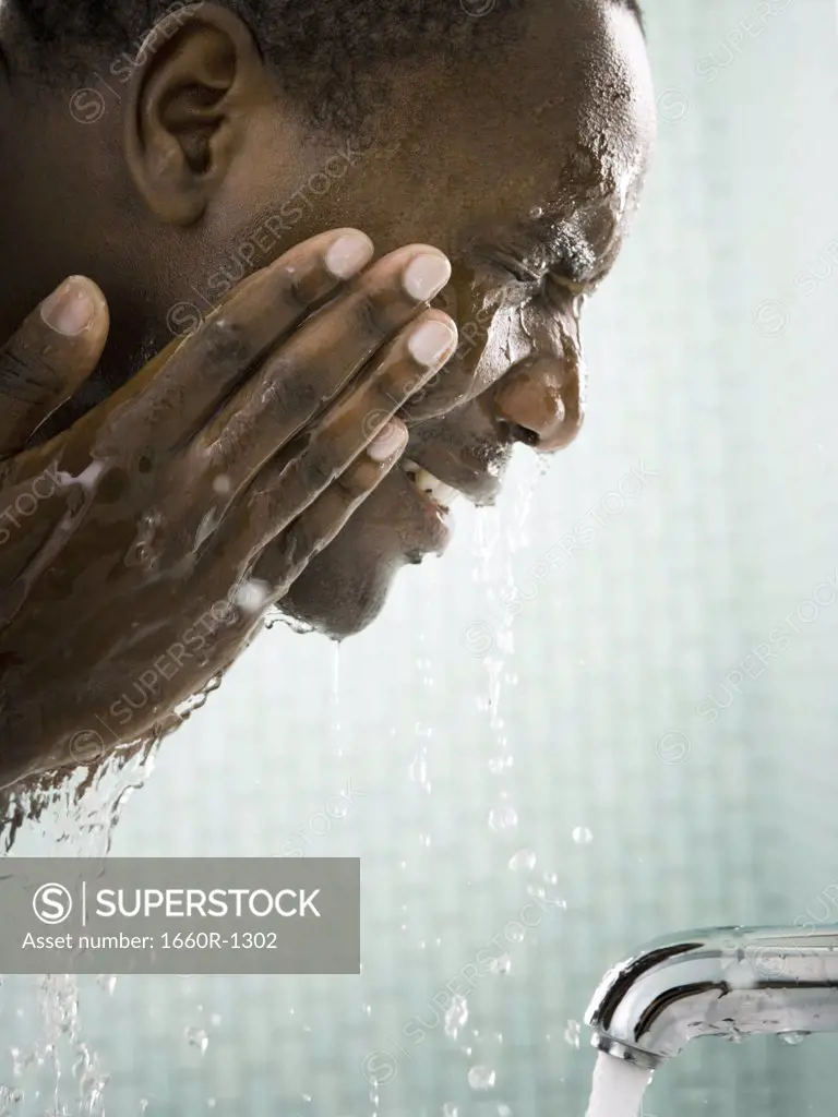 Close-up of a mid adult man washing his face