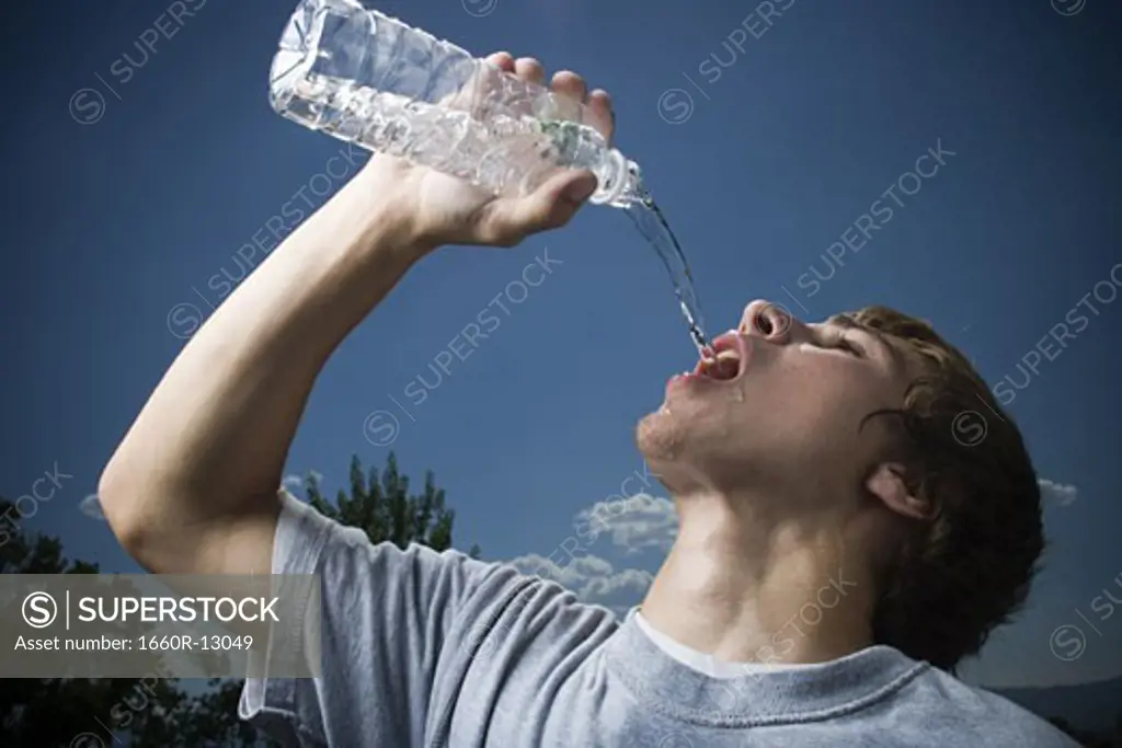 Close-up of a teenage boy drinking water from a water bottle