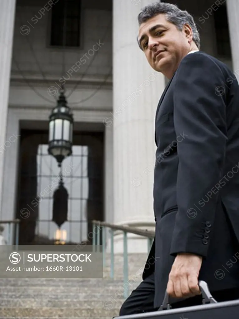 Low angle view of a man walking up the steps of a courthouse