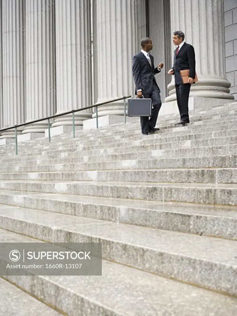 Low angle view of two men standing on the steps of a courthouse
