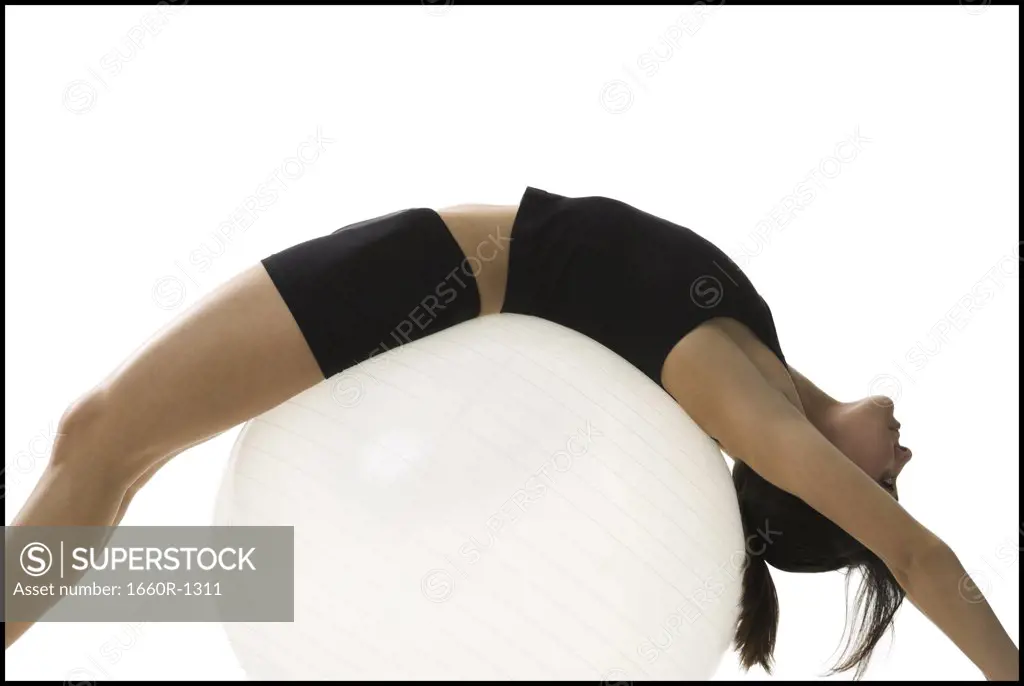 Profile of a mid adult woman exercising on a fitness ball