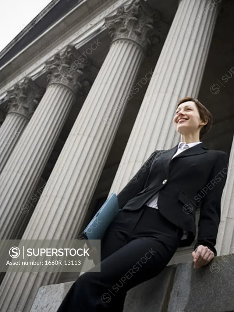 Low angle view of a female lawyer holding a file and smiling
