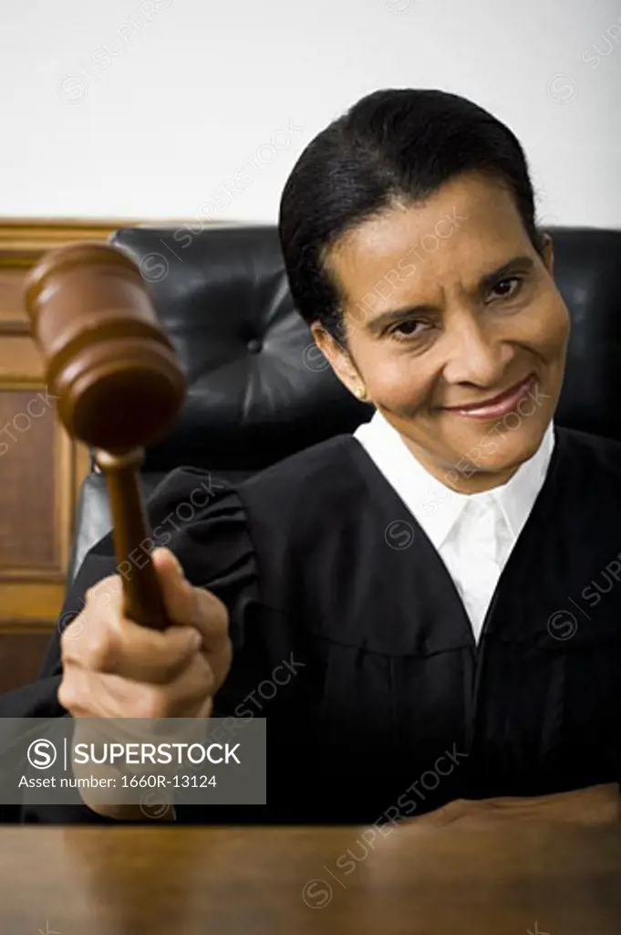 Portrait of a female judge holding a gavel and smiling