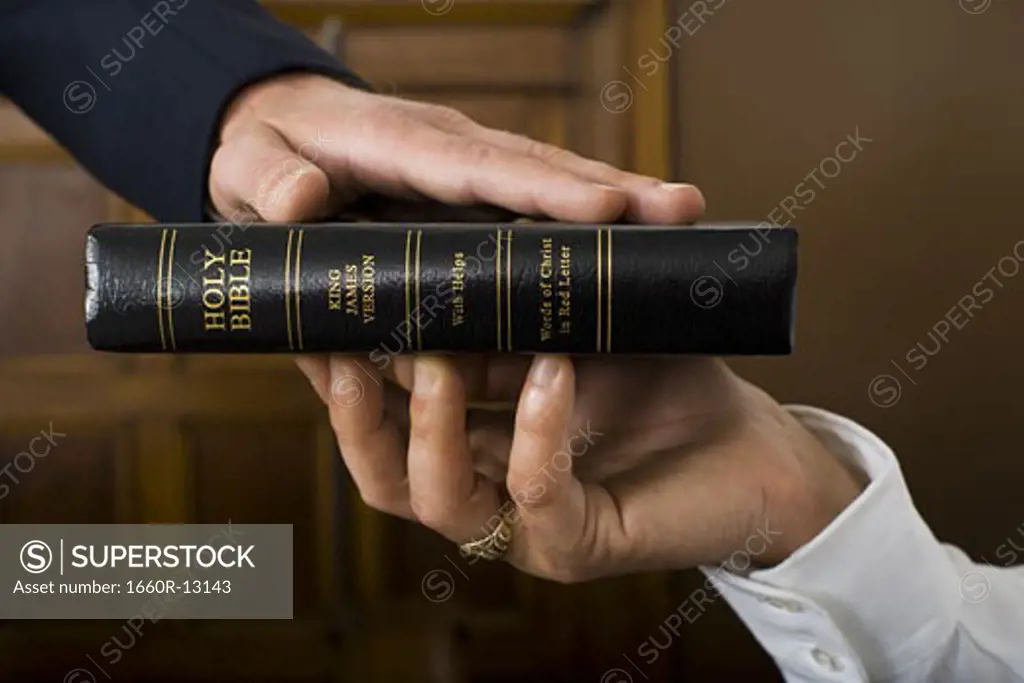 Close-up of a witnesses hand swearing over the Bible