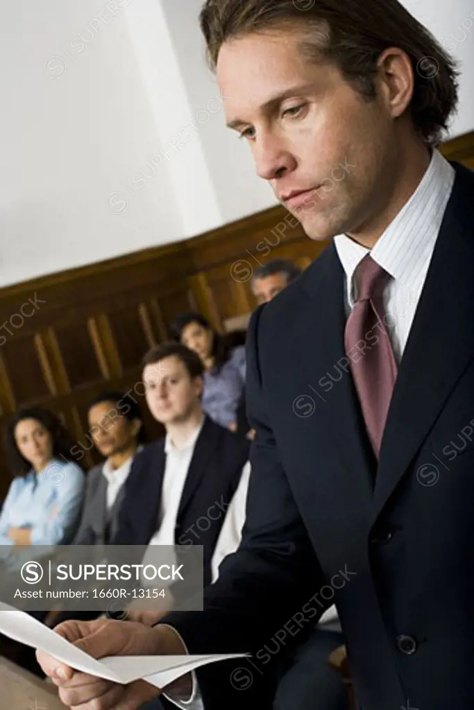 A juror standing in a jury box and reading the verdict