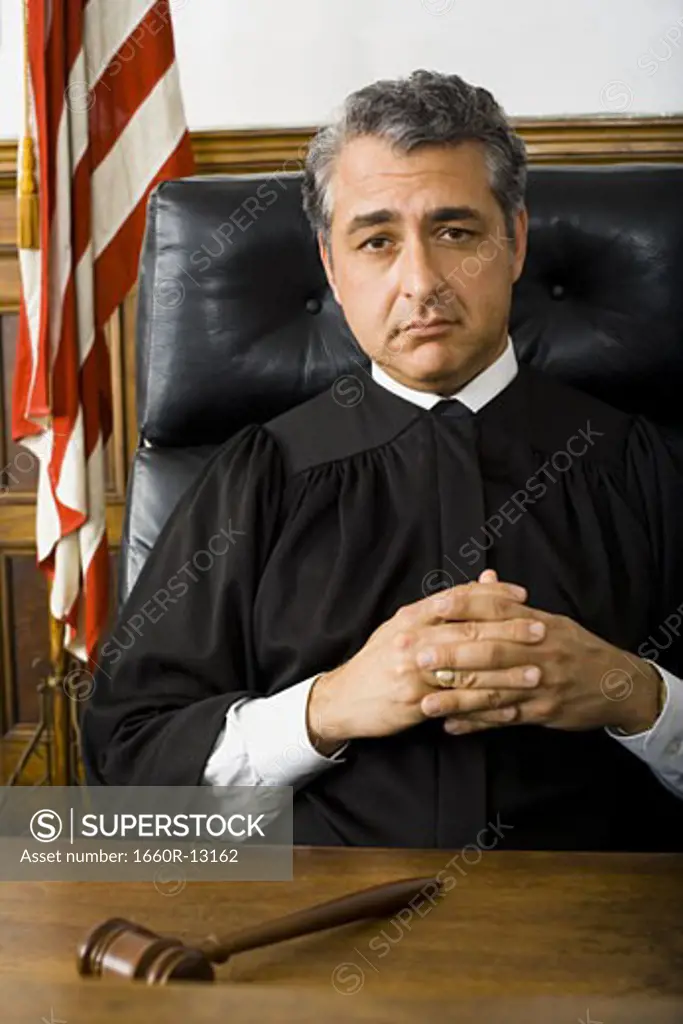 Portrait of a male judge sitting with his hands clasped