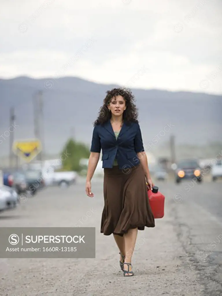 A young woman walking with a gas can