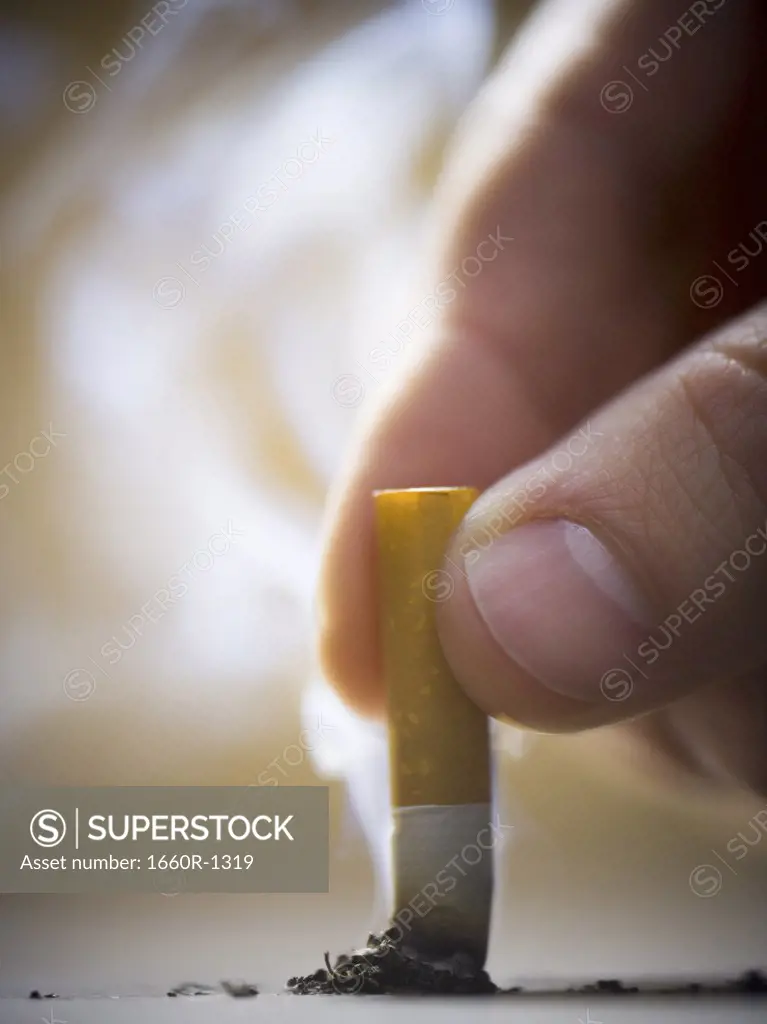 Close-up of a man putting out a cigarette