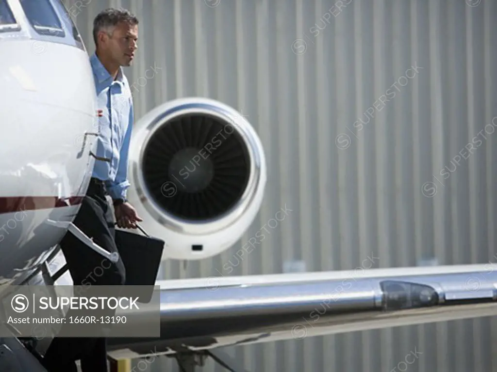Profile of a businessman exiting an airplane
