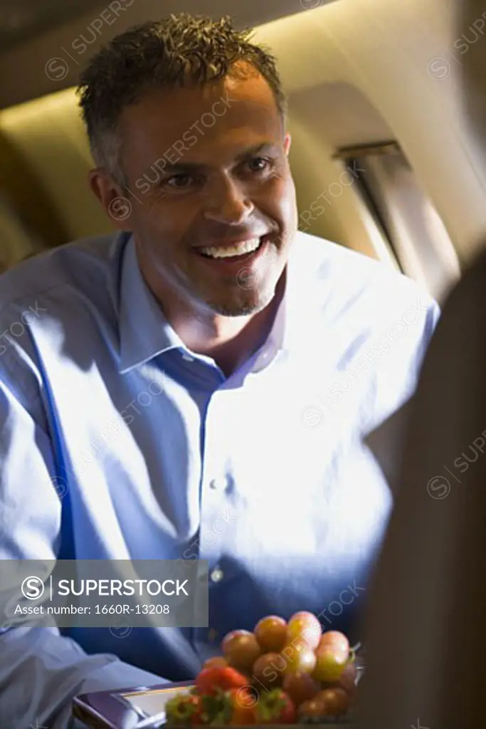 A businessman smiling in an airplane