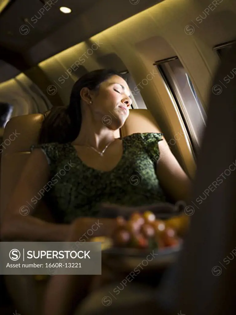 A businesswoman sleeping on an airplane