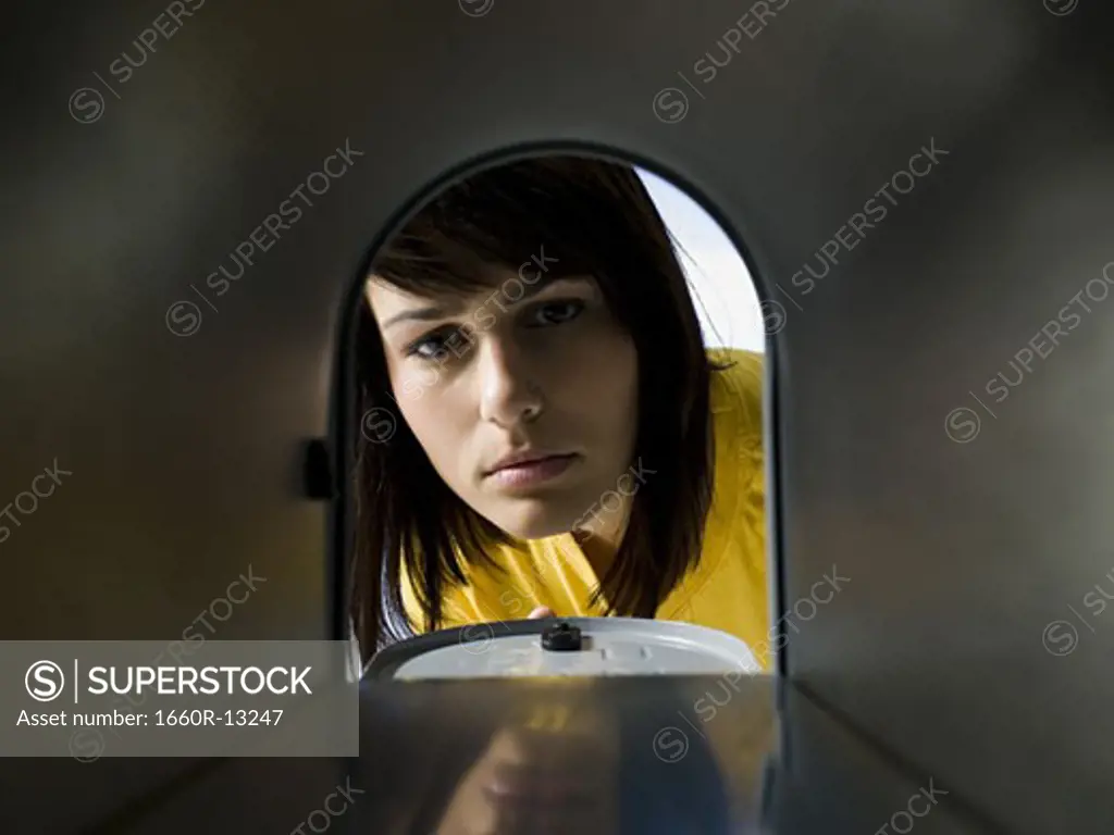 Close-up of a young woman looking at an empty mailbox