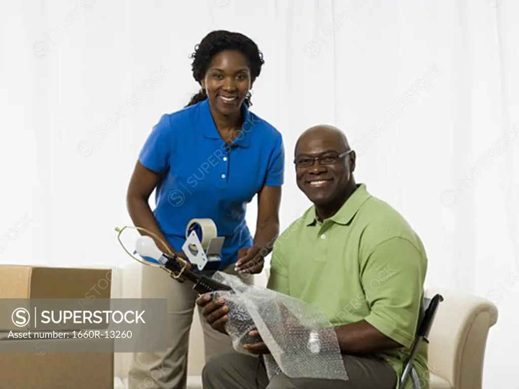 Portrait of a senior couple smiling and packing up a lamp