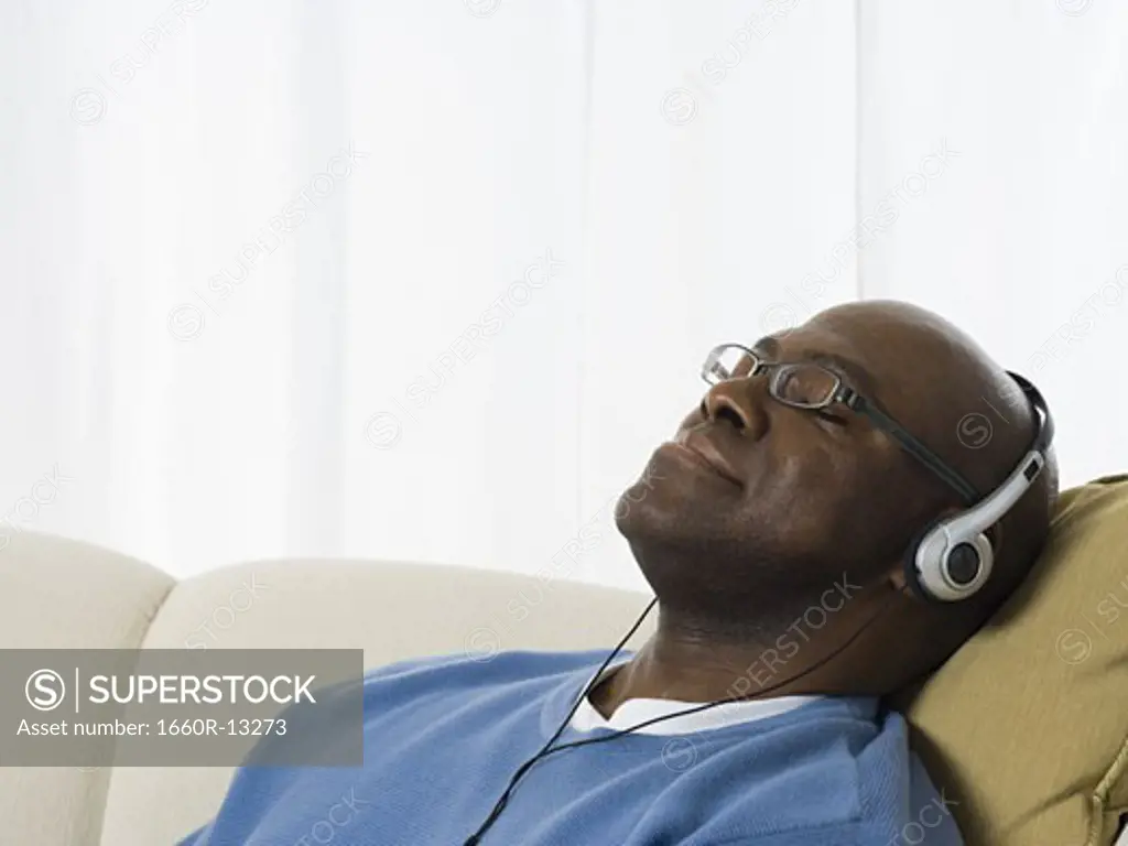 Close-up of a senior man wearing headphones and listening to music