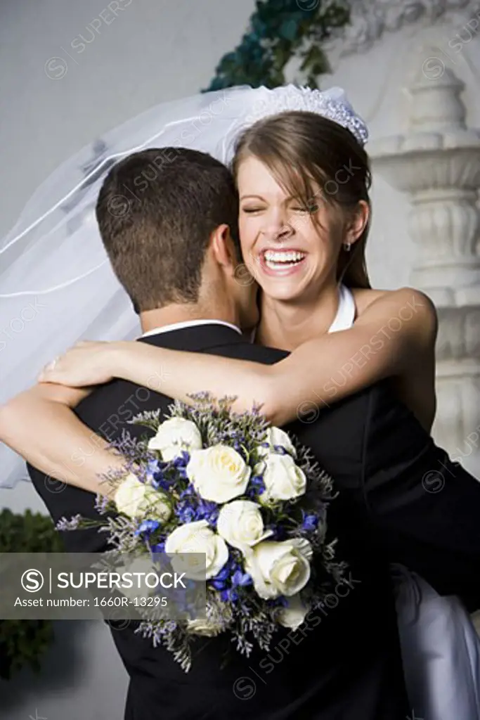 Close-up of a newlywed couple embracing each other and smiling