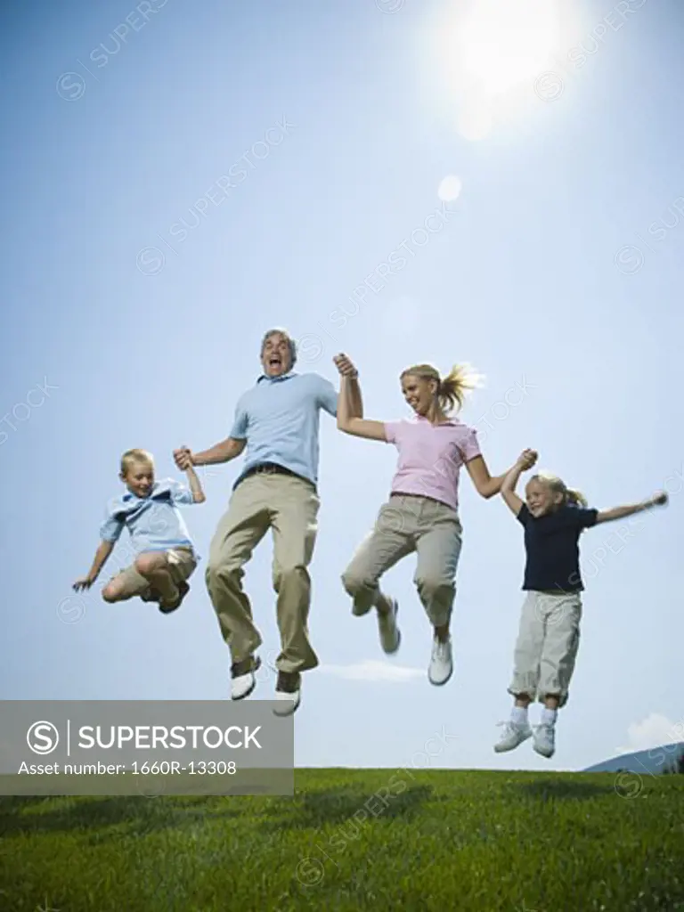 Low angle view of parents and their two children jumping