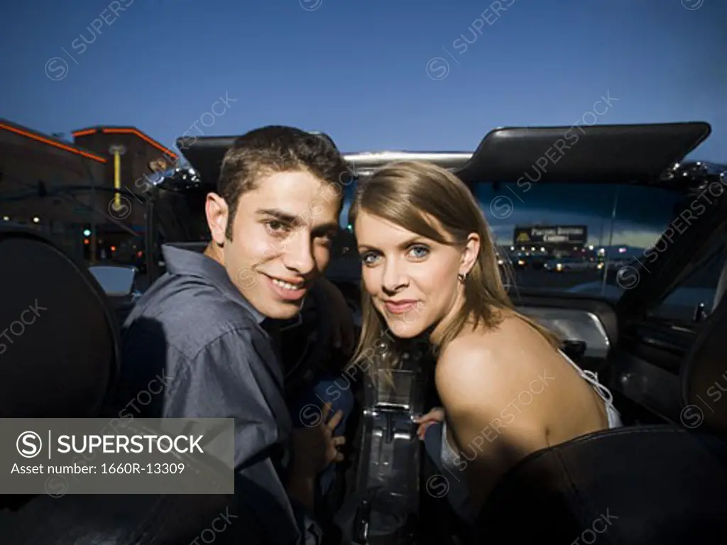 Portrait of a young couple sitting in a car and smiling