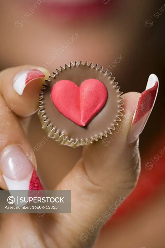 Close-up of a young woman's hand holding a chocolate