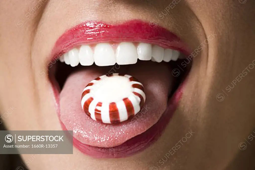 Close-up of candy on a young woman's tongue