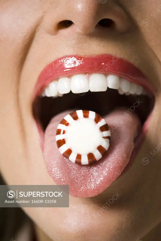 Close-up of candy on a young woman's tongue