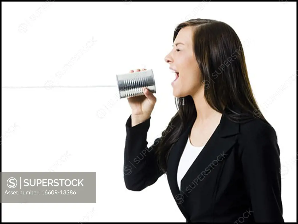 Profile of a teenage girl holding a tin can phone and shouting