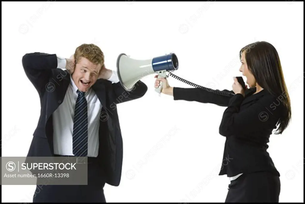 Profile of a teenage girl shouting in a megaphone with a businessman covering his ears