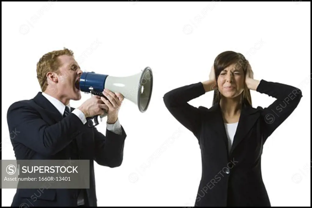 Profile of a businessman shouting into a megaphone with a teenage girl covering her ears