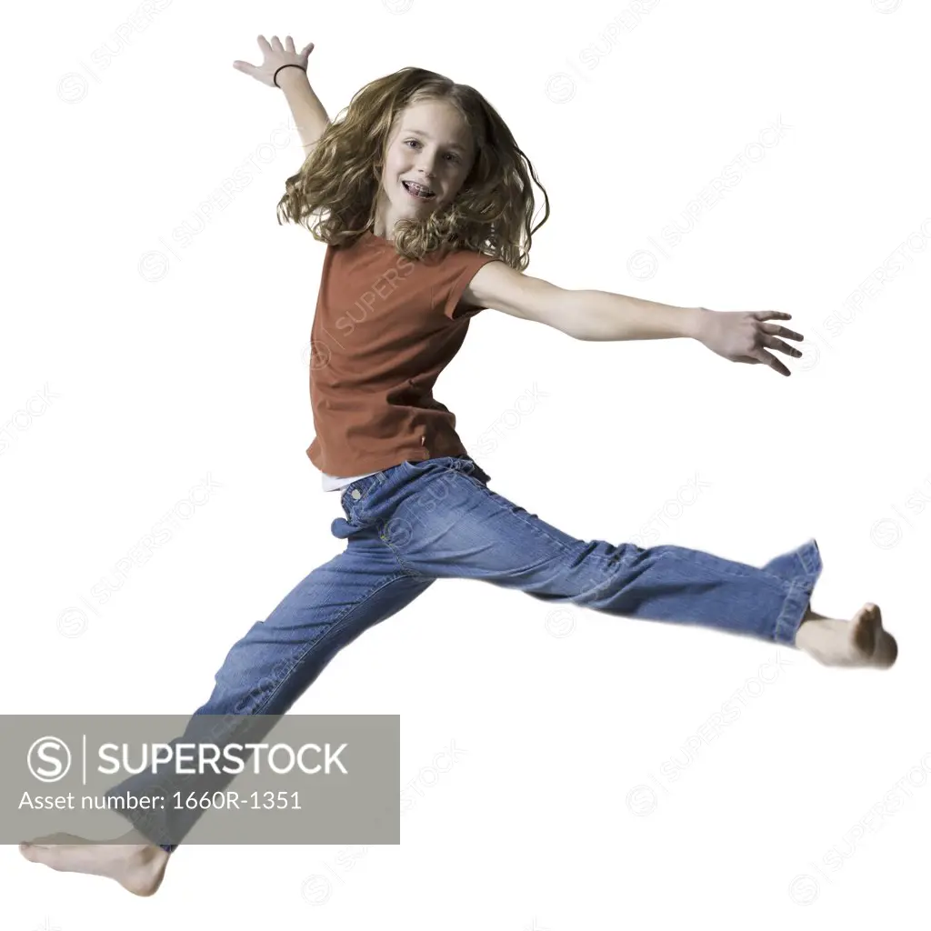 Portrait of a teenage girl jumping with her arms outstretched